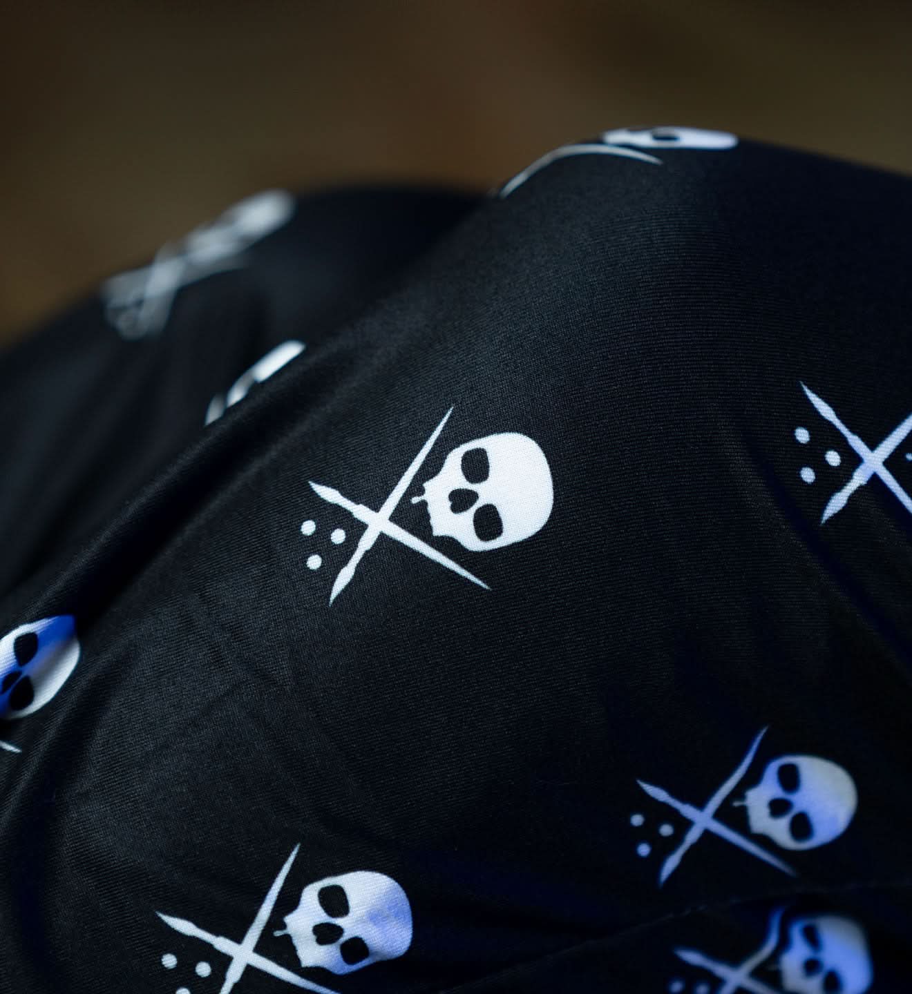 Black fabric with white skull and crossbones pattern