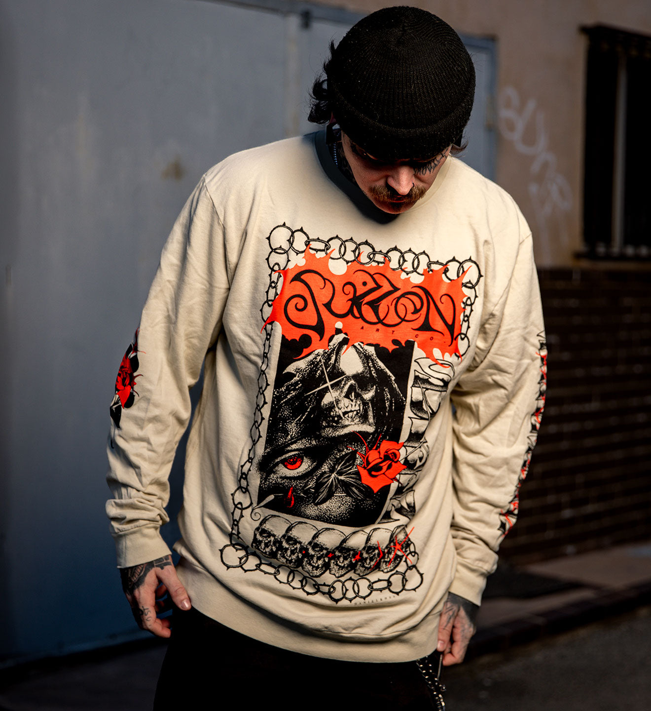 Person wearing a graphic sweatshirt with a skull design in an urban setting