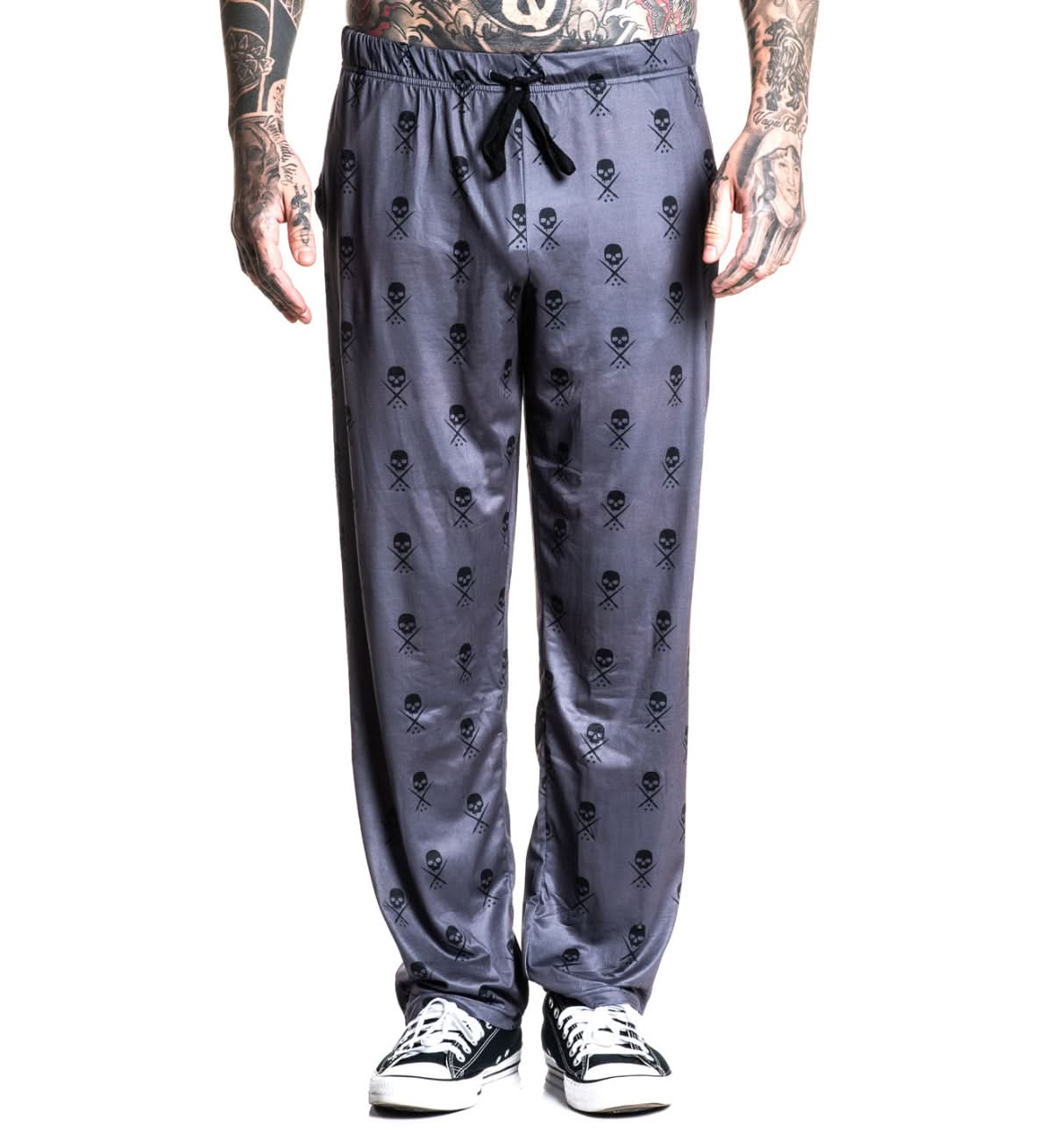 Person wearing gray sweatpants with skull and crossbones pattern on a white background