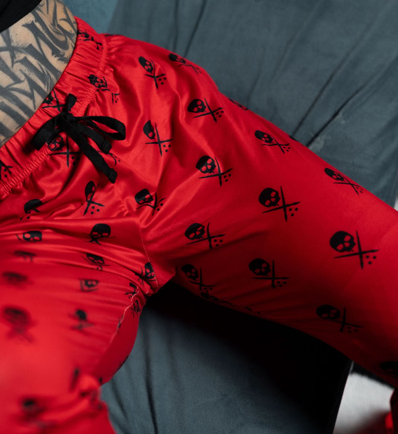Red shorts with black skull patterns on a dark surface
