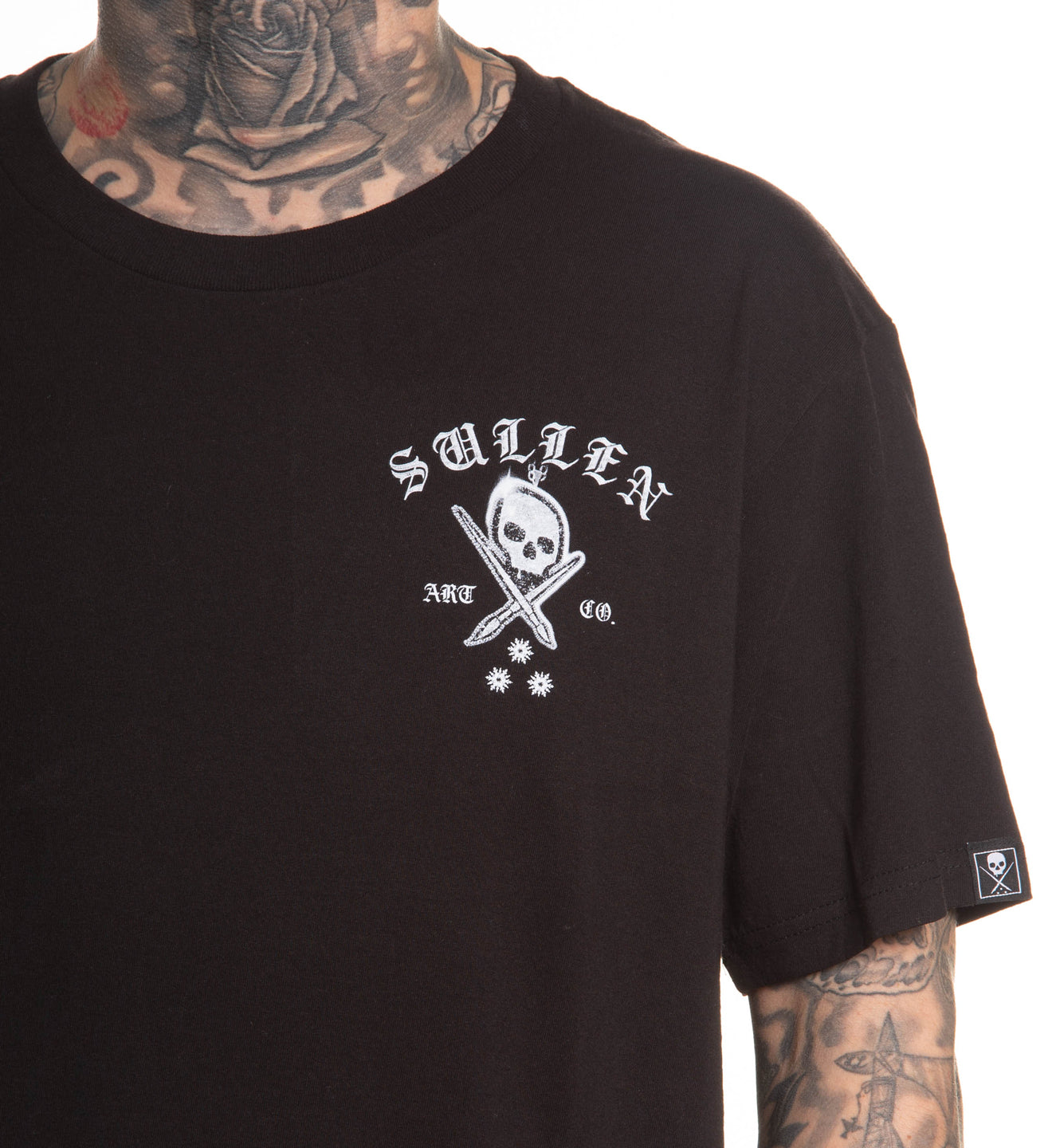 Black t-shirt with a white logo featuring a skull and sword, worn by a person with tattoos.