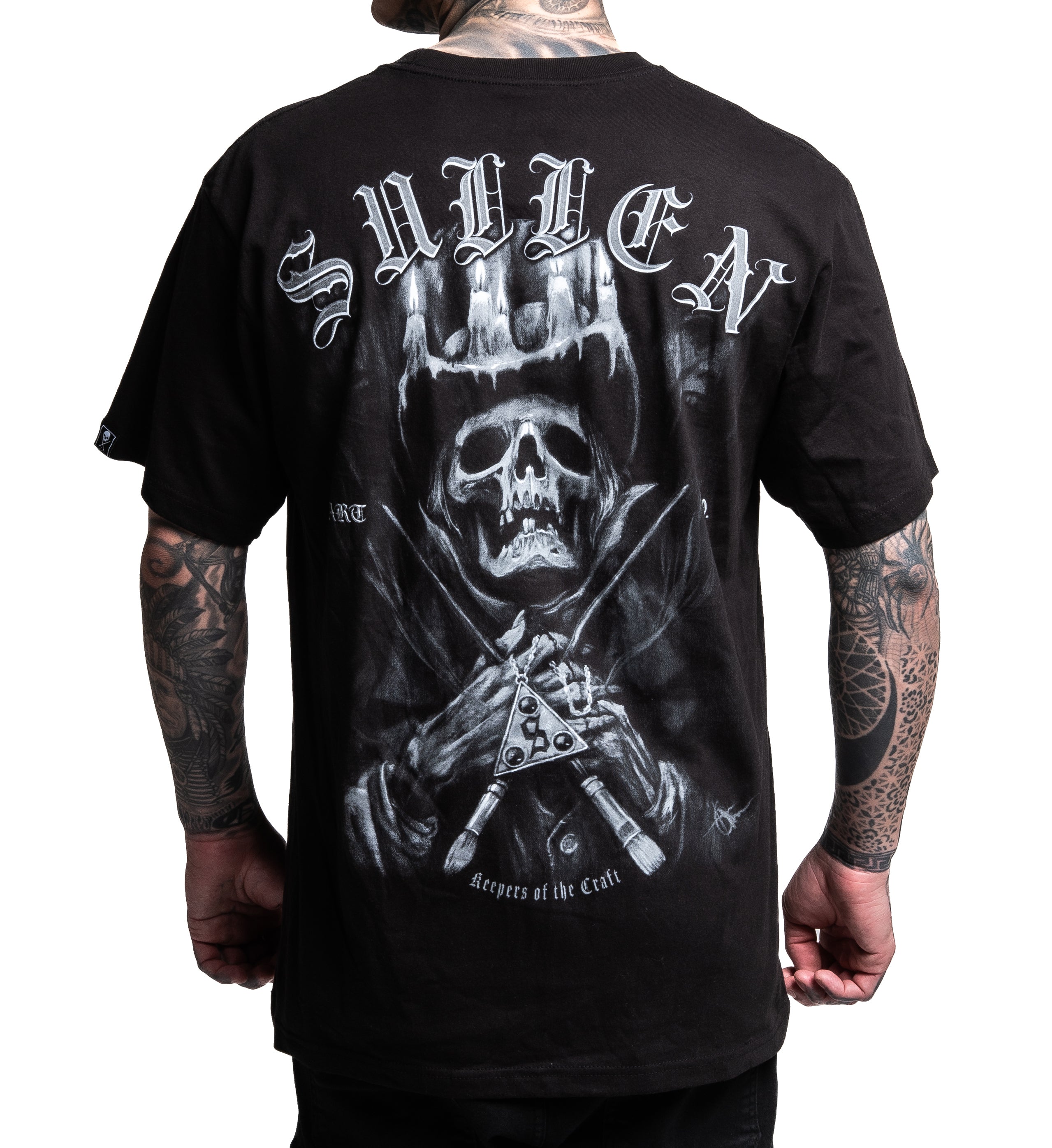 Black t-shirt with a graphic design on the back featuring a skull and crossed daggers, worn by a person.