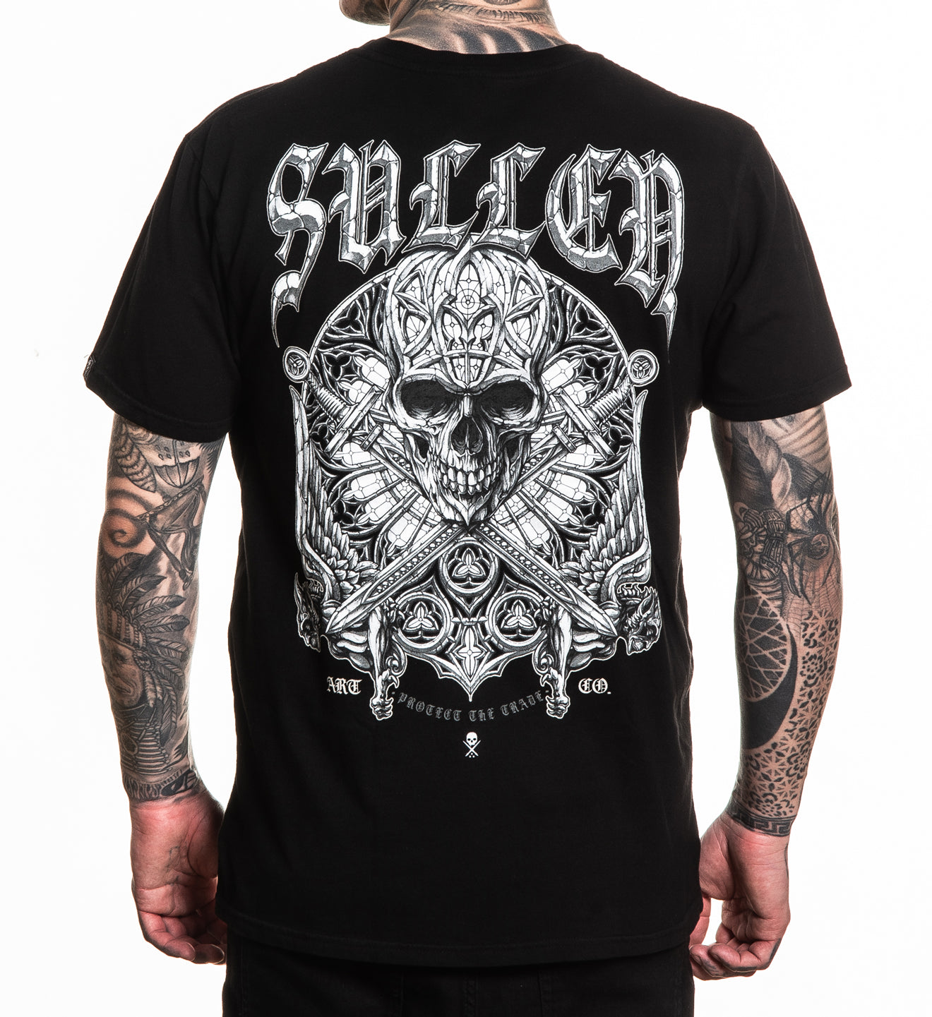 Black t-shirt with intricate skull design and 'Sullen' branding on the back, worn by a person with tattoos.