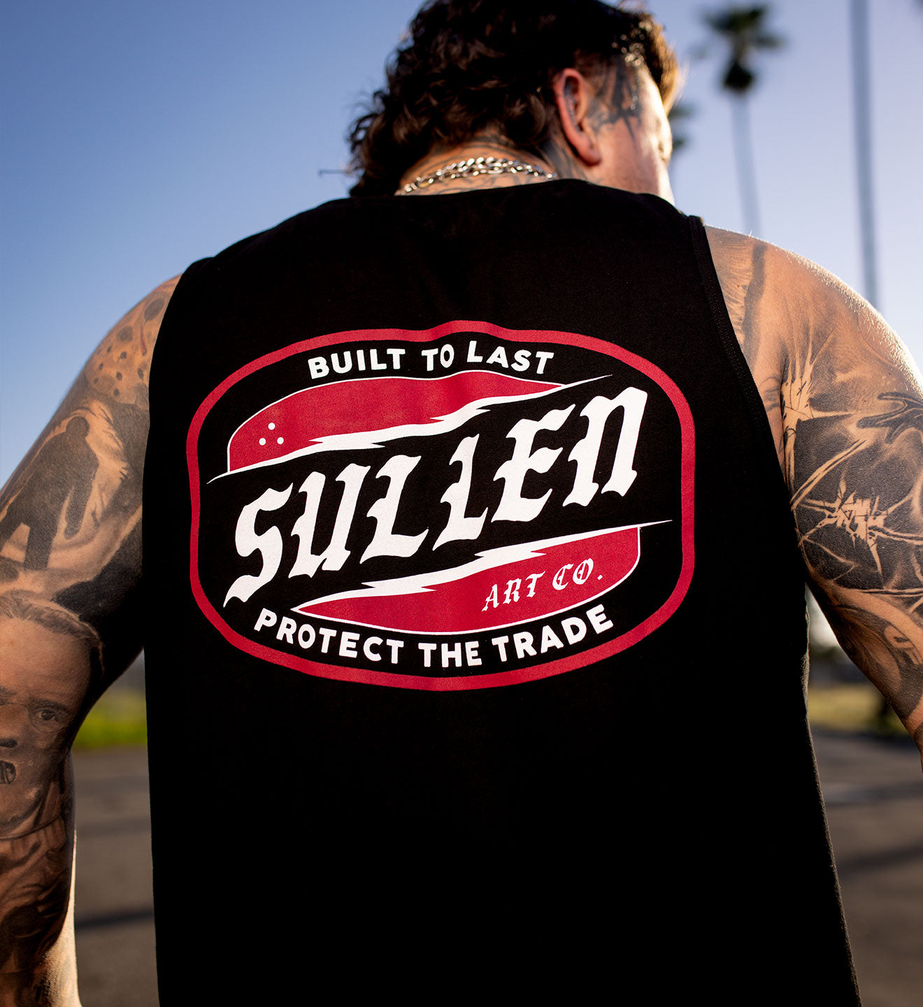 Person wearing a black sleeveless shirt with 'Sullen Art Co.' logo on the back.