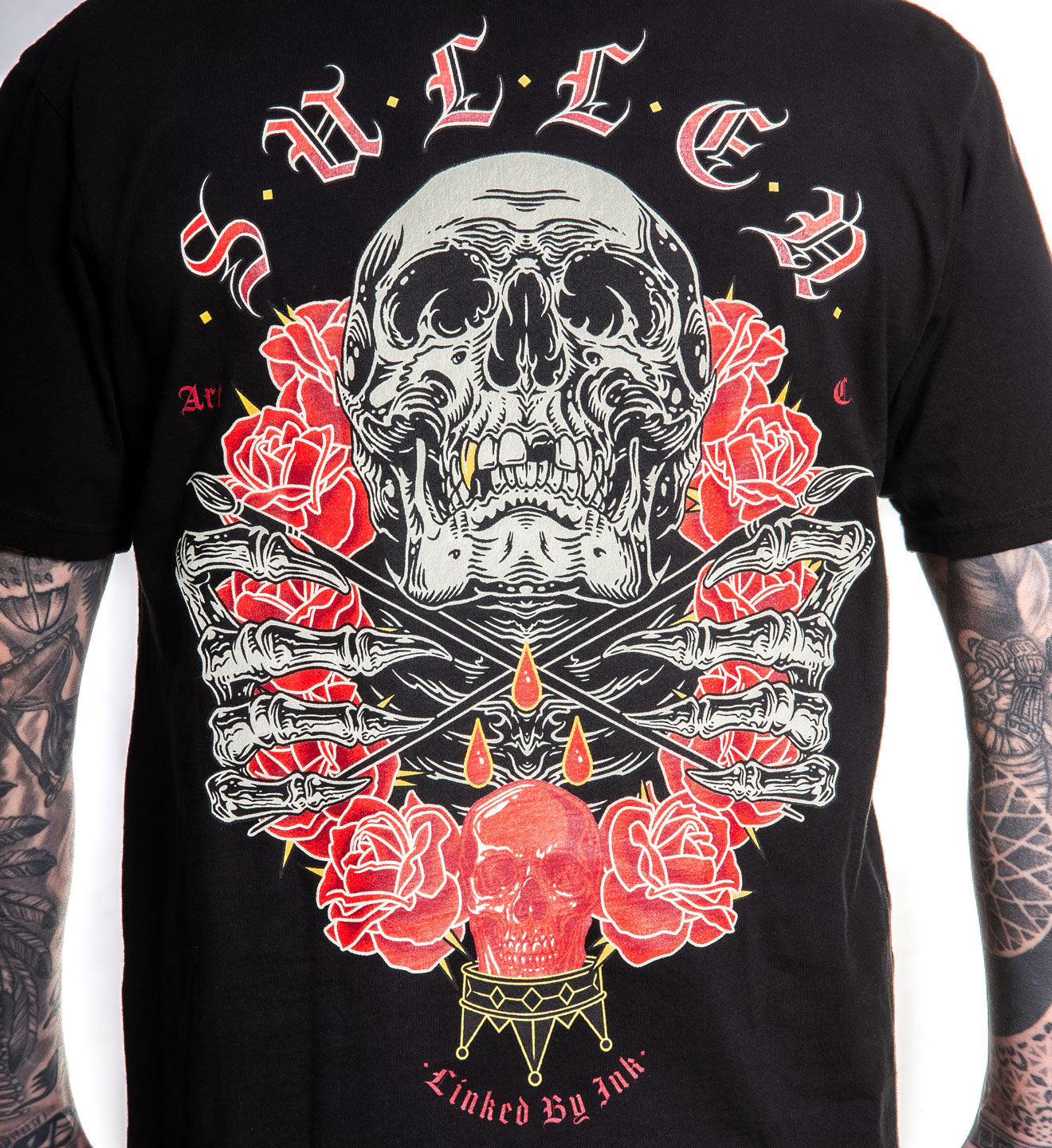 Black t-shirt with a skull and roses design on a plain background