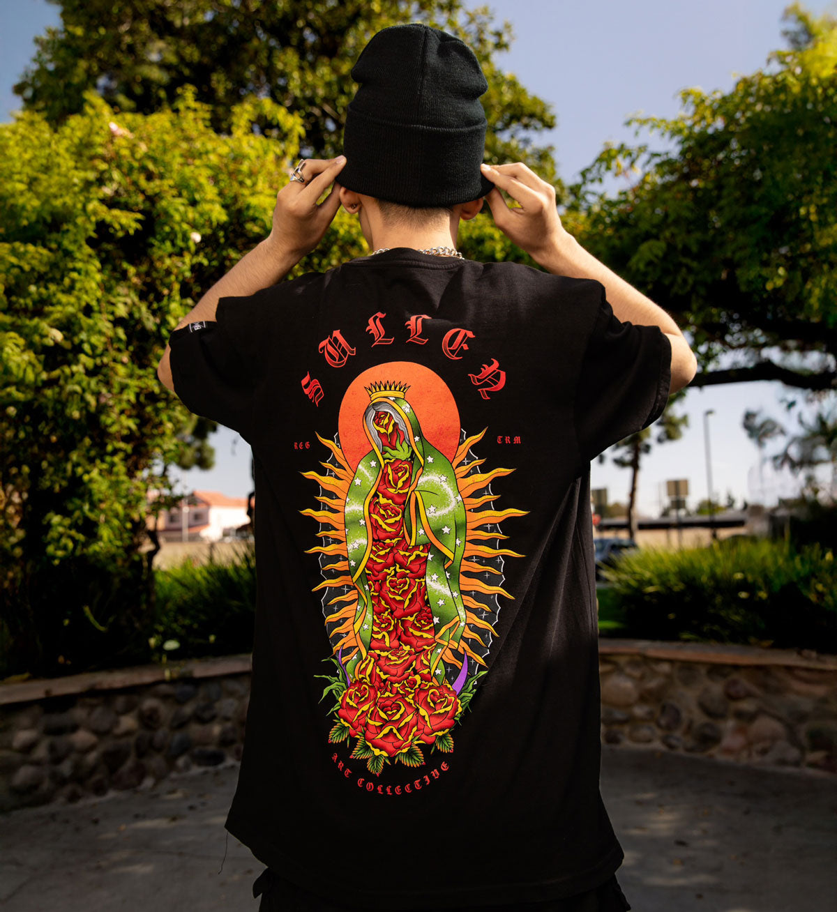 Person wearing a black t-shirt with colorful graphic design outdoors