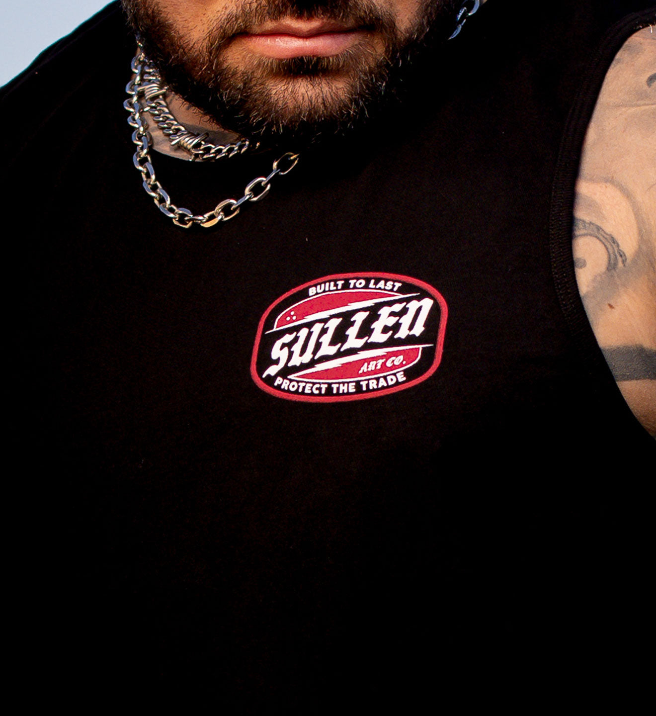 Black sleeveless shirt with Sullen logo worn by a person
